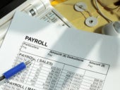 Payroll spreadsheet with computer monitor and mouse.